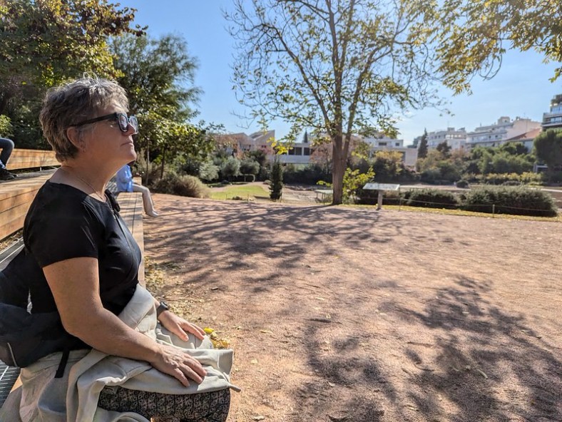 Sunny day in Athens, one lady on the left is looking right, into the distance. The location is Aristotle's Gymnasium.